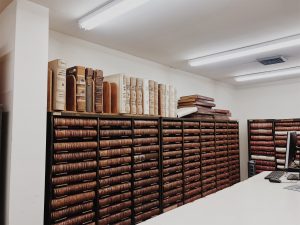 Rows of antique bound volumes on library shelves