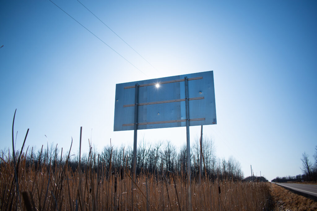 An eastbound Mille Lacs Reservation road sign on Highway 27, riddled with four bullet holes in March 2025. Local authorities dismissed the idea that racial tensions played a role in the sign's defacement. However, other road signs a mile in either direction were not vandalized.