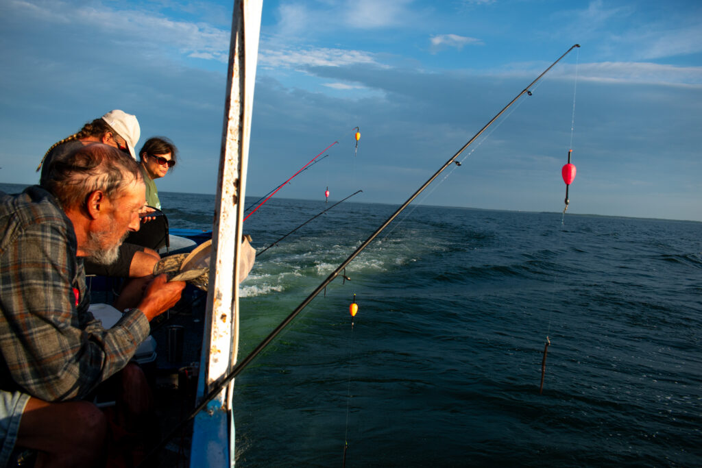 Mille Lacs area locals and tourists ride a piloted launch boat on a guided fishing expedition in July 2025. The state's second-largest lake is a popular sports-fishing destination despite state-imposed limits on walleye catches. Although the walleye lures most anglers from across the state, Mille Lacs has a notable bass fishery as well.